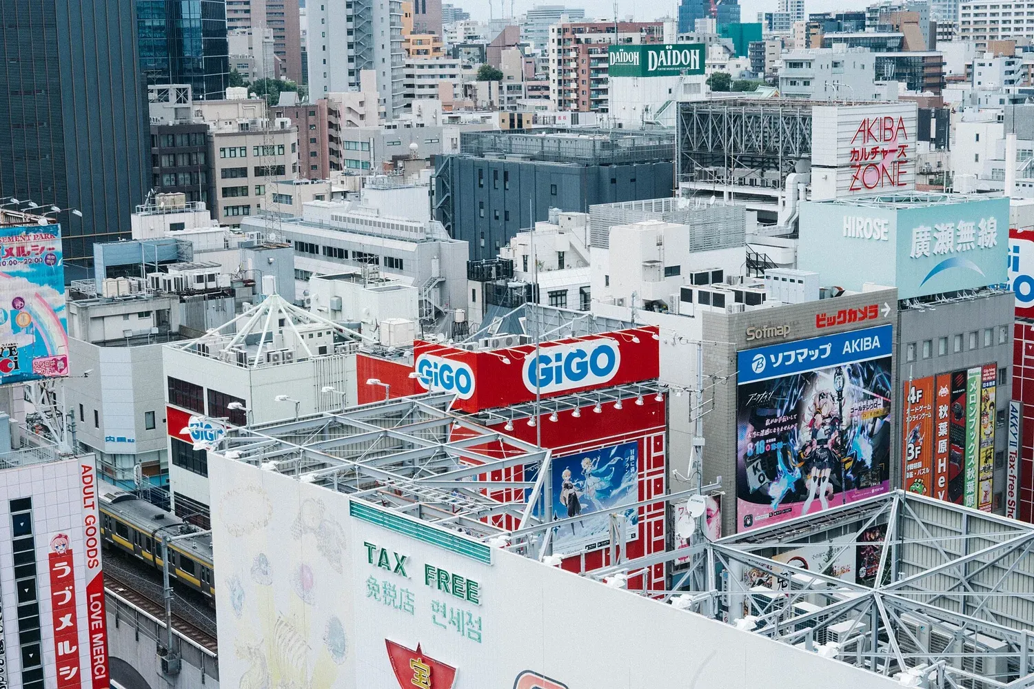 Rooftops and building signs of Akihabara seen from above, with GiGO and Sofmap signs among the buildings