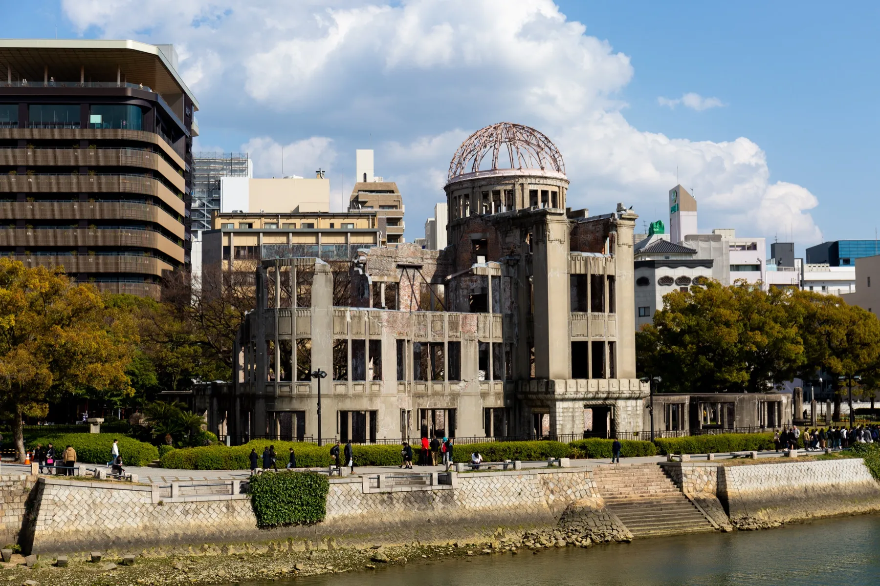 The Atomic Bomb Dome in Hiroshima under a blue sky, seen across the river