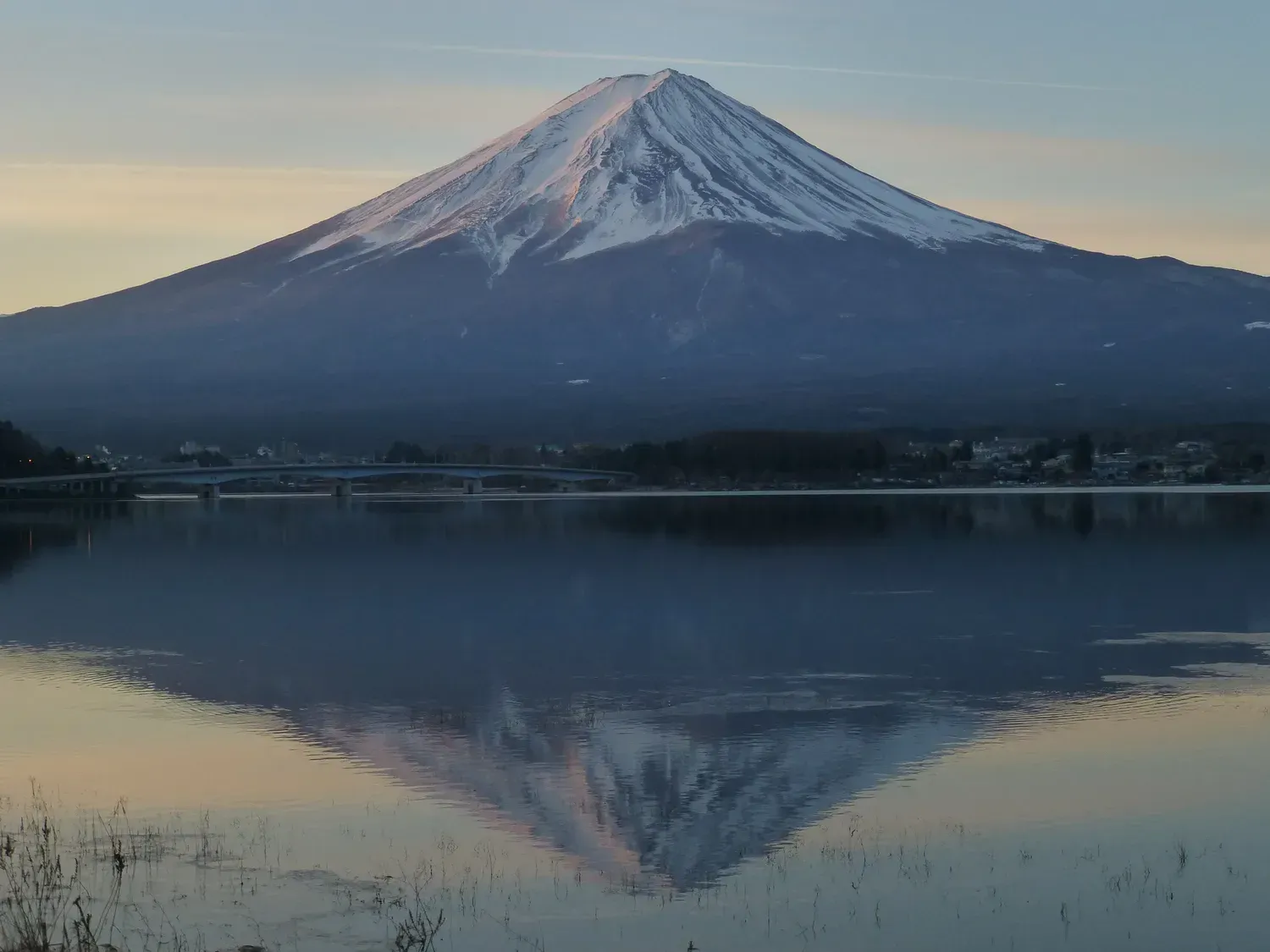 Snow-capped Mount Fuji above Lake Kawaguchi, reflected upside down in the still water