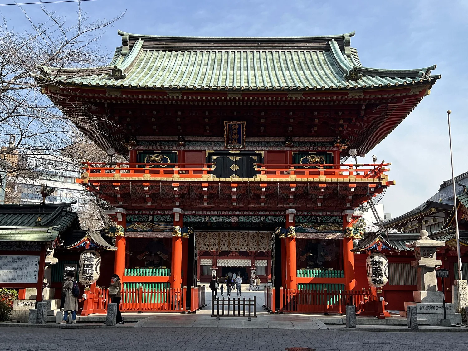 The red and green Zuishin-mon gate of Kanda Myojin shrine under a blue sky