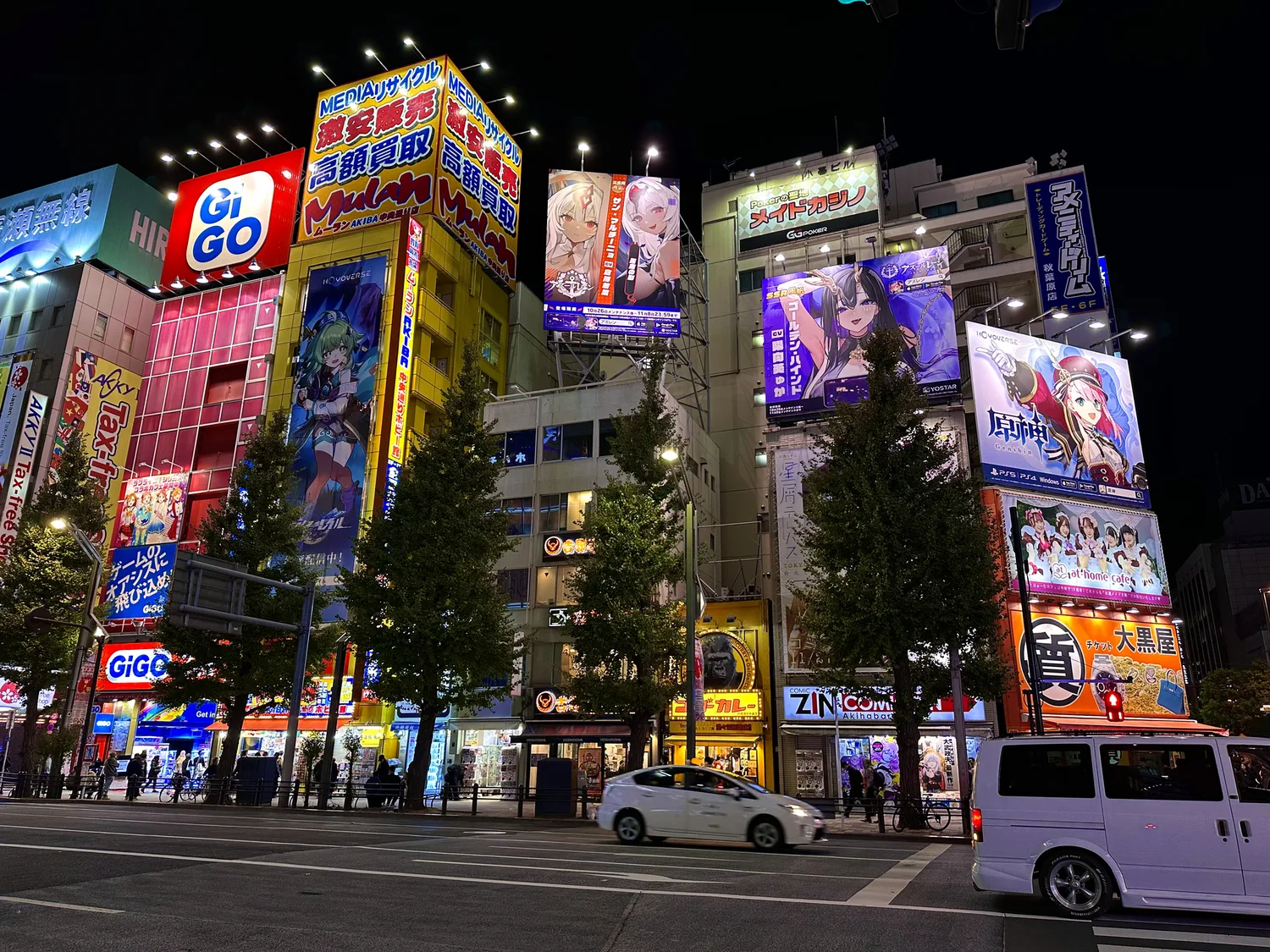 Akihabara's electric town at night, with lit-up anime billboards and GiGO signs above a quiet street
