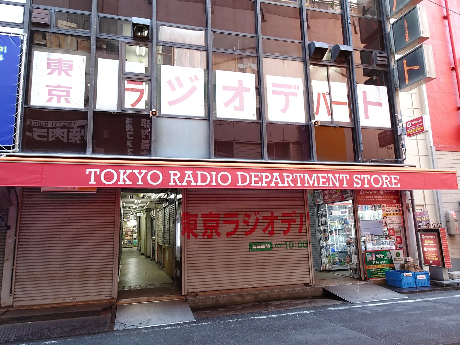 The Tokyo Radio Department Store with its red English sign above shuttered shop fronts, before opening time