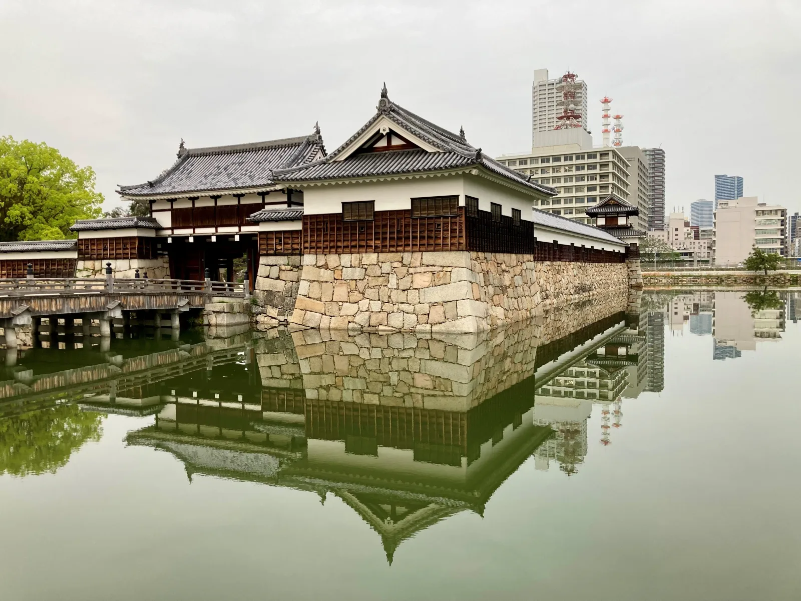 A rebuilt gate and turret of Hiroshima Castle reflected in the moat