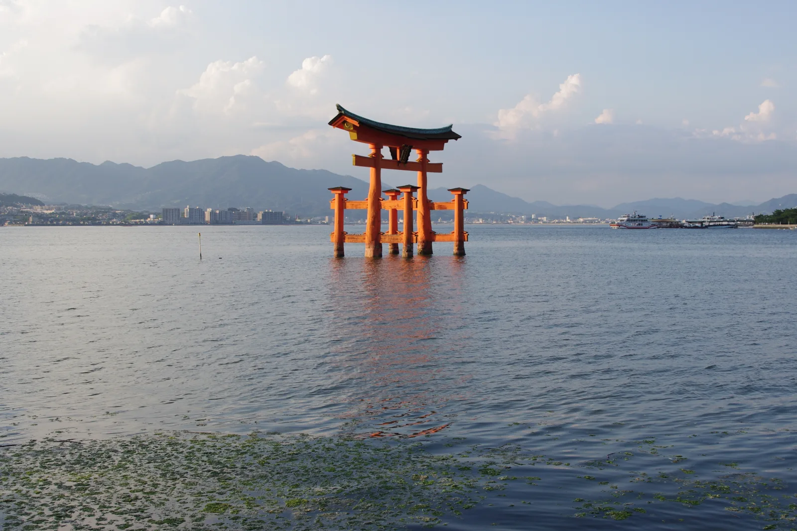 The great torii standing in open water at high tide, its pillars submerged at the base