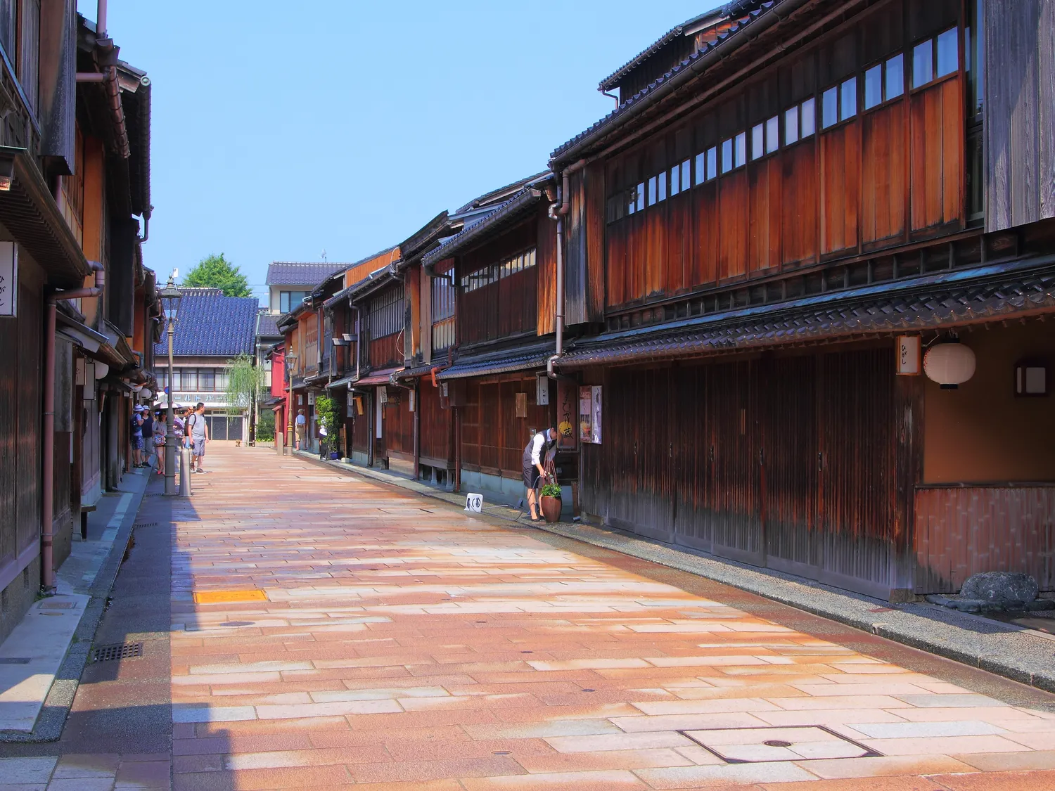 A quiet stone-paved street in Higashi Chaya, two-storey lattice-fronted teahouses on both sides
