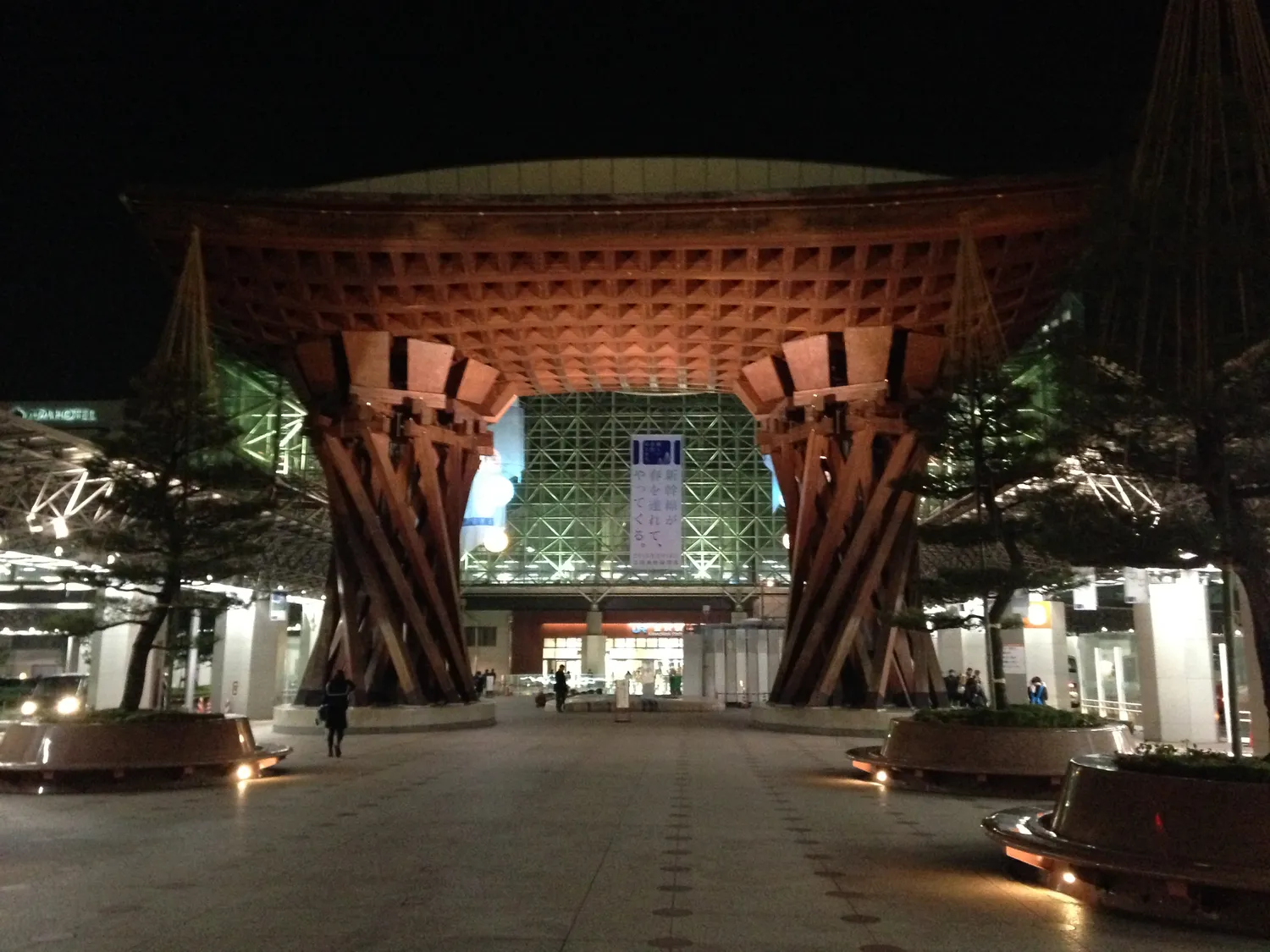The Tsuzumi-mon gate outside Kanazawa Station lit at night, the glass dome behind it