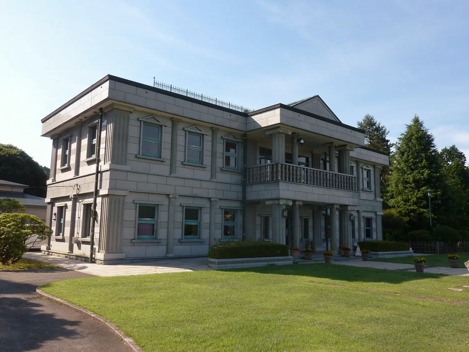 A two-story Western-style building with a balcony, on a lawn