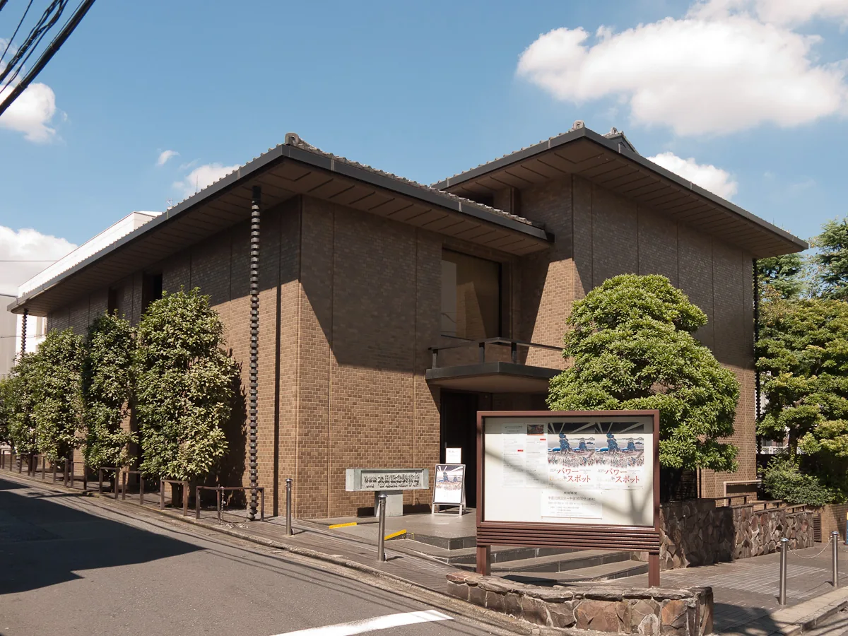 The Ota Memorial Museum of Art building in Harajuku under a blue sky, with a signboard in front