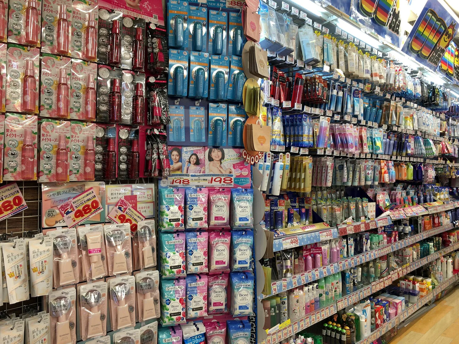 A store aisle with shelves packed from floor to ceiling with cosmetics and everyday goods