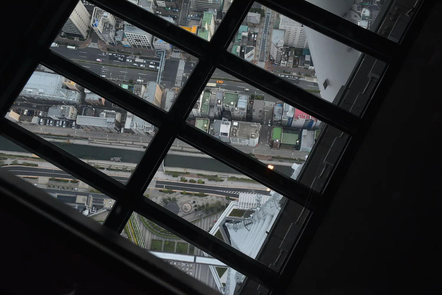 Looking down through the glass floor of Tokyo Skytree at roads and rooftops far below