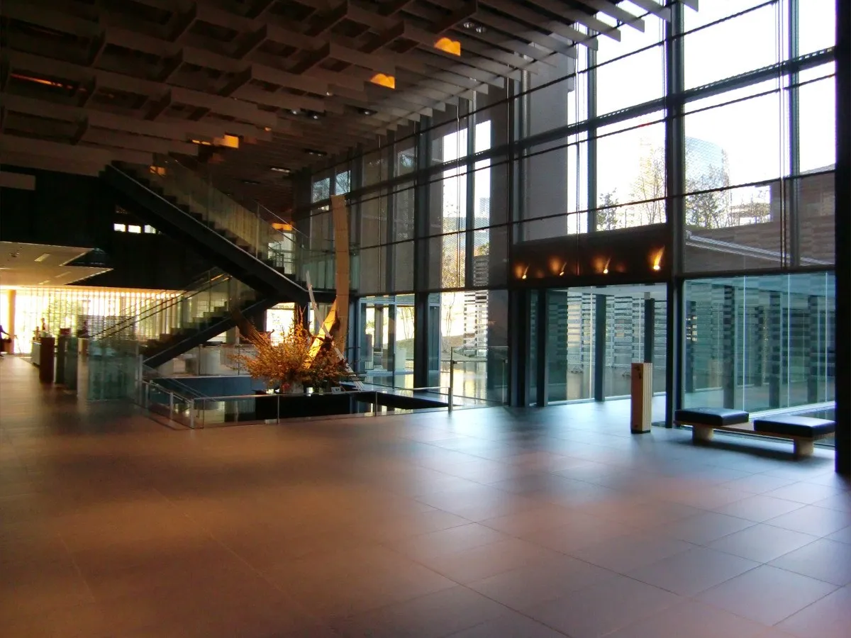 The main lobby of The Capitol Hotel Tokyu: a tall space with a polished floor, wooden louvres and a wall of windows onto greenery