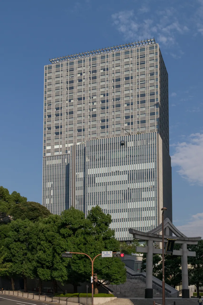 The tower that houses The Capitol Hotel Tokyu, with the torii and trees of Hie Shrine at its foot
