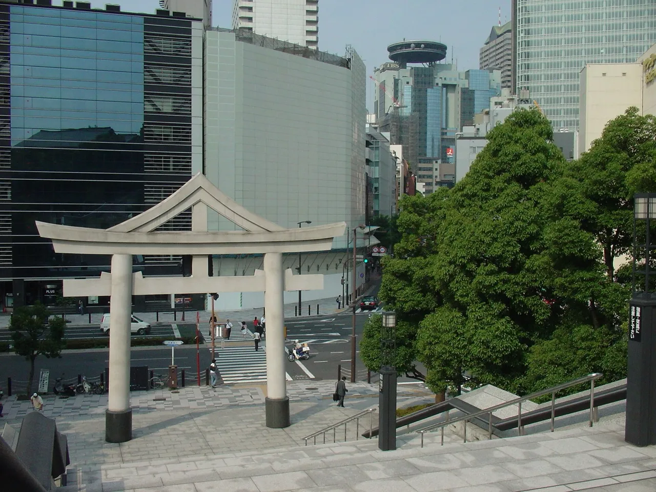A torii gate at the top of the stone steps of Hie Shrine in Akasaka, with office towers around it