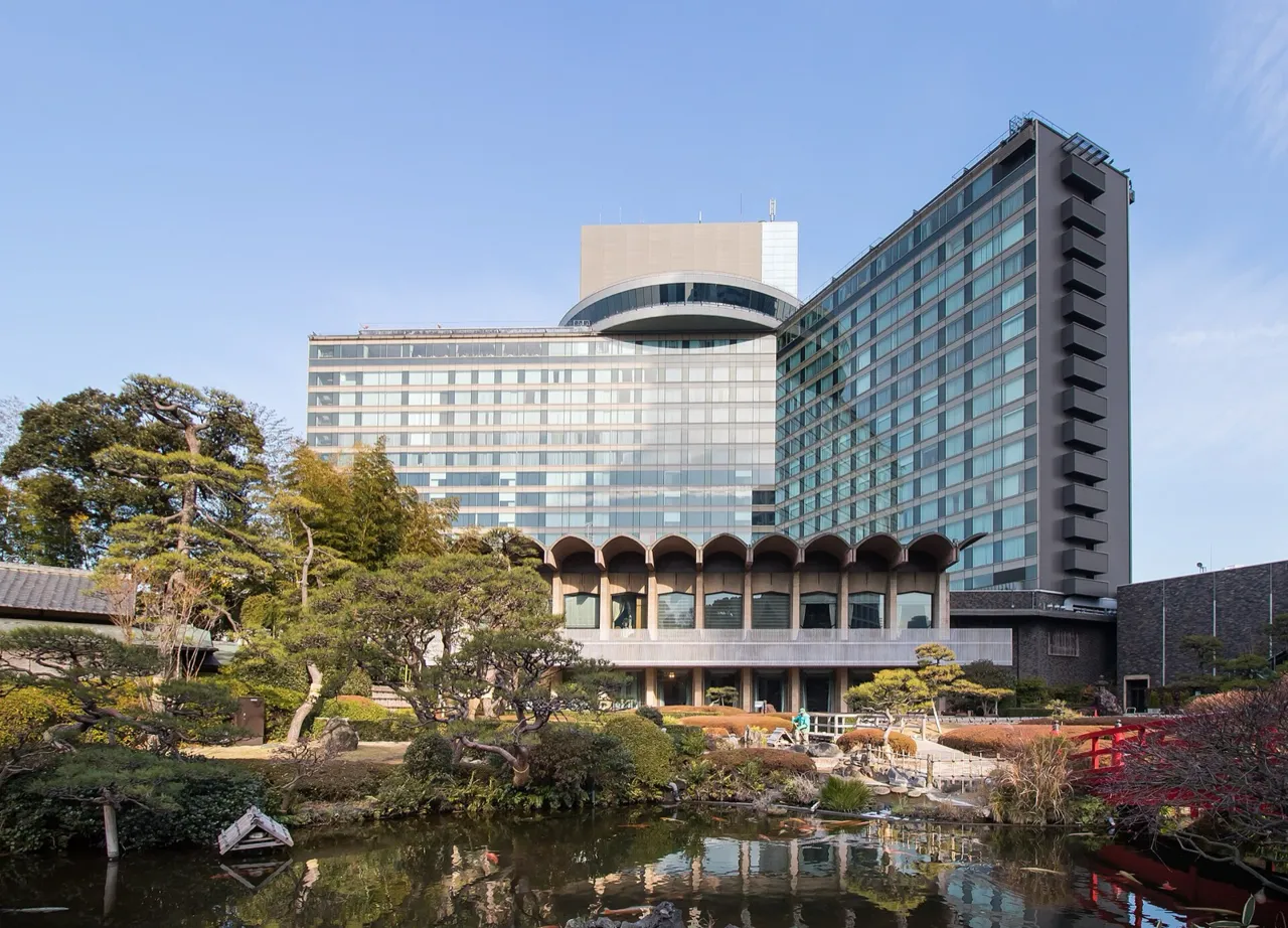The Main building of the Hotel New Otani Tokyo seen across the pond of its Japanese garden on a clear day